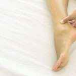 woman-hand-holding-ankle-with-pain-on-white-bed-health-care-and-picture-id941217678