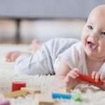 cute-baby-sings-with-open-mouth-while-playing-with-wooden-blocks-picture-id865900638