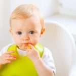 Portrait of eat smeared baby sitting in baby chair