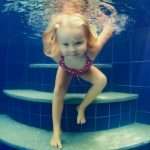 child-jump-underwater-into-swimming-pool-picture-id891344714