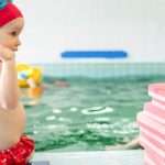 child-sitting-at-swimming-pool-picture-id694106426