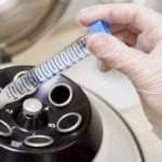 Embryologist putting sample into centrifuge