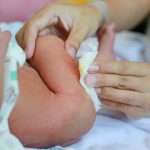 mother-cleaning-newborn-baby-feces-picture-id911891630