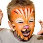 Kid with lion painted face. On white background.