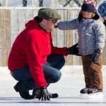 Family having fun at the outdoor skating rink in winter.