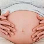 Close up of a couple touching the belly of the pregnant woman