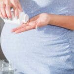 Pregnant woman taking pill