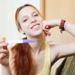 Smiling woman with pregnancy test