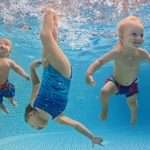 children-swim-and-dive-underwater-with-fun-in-swimming-pool-picture-id545777268