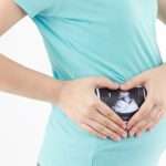 pregnant-woman-is-holding-a-photo-of-her-ultrasound-picture-id590169548