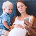 pregnant-mother-and-son-looking-in-mobile-smart-phone-picture-id835757376