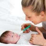 beautiful-blond-woman-and-mother-or-doctor-is-feeding-baby-medicine-picture-id959608078