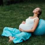 pregnant yoga prenatal doing different exercises with fitball. in park