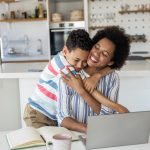 Boy supporting his mother while working at home